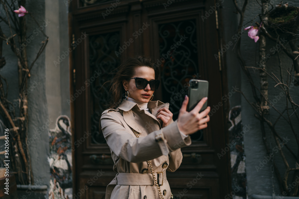 Girl takes selfie while posing in front of mobile phone