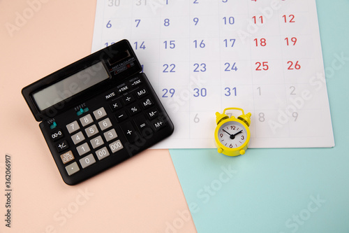 Alarm clock, calculator and calendar - business or tax time concept.