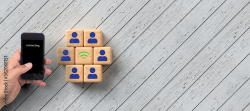 cubes with people symbols and wifi symbol between them on wooden background