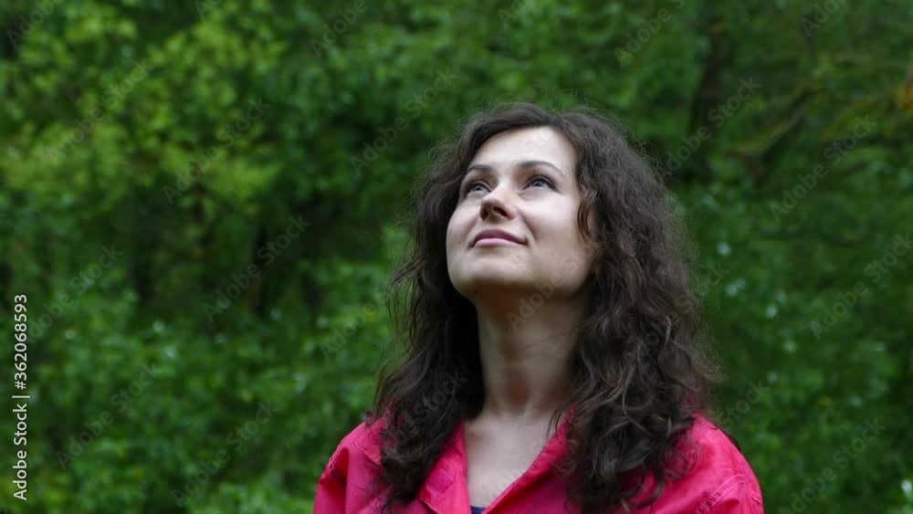 Girl in rainy weather looks at the sky. Girl in a red coat. Breathe in the fresh air in nature. Girl in rainy weather looks at the sky. Girl in a red coat. Breathe in the fresh air in nature.