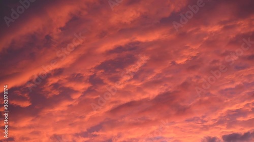 Pink clouds float at sunset and gradually turn blue