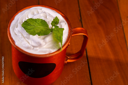 Moscow mules cocktail in copper mugs with green mint leaves. Beautiful and delicius Moscow Mule drinks served on a wooden table photo