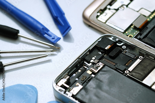 Technician repairing the Cell phone parts and tools for recovery repair phone smartphone and upgrade mobile technology,the concept of computer hardware inside.