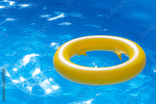 Beautiful refreshing blue swimming pool with Inflatable yellow ring. summer swimming holiday background.