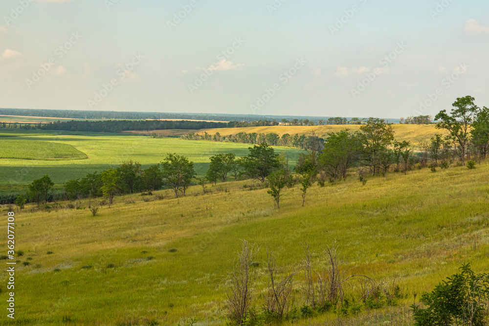 Obraz premium View from the hill to the river and agricultural fields to the horizon and blue sky. Russia, Krasnodar Territory.