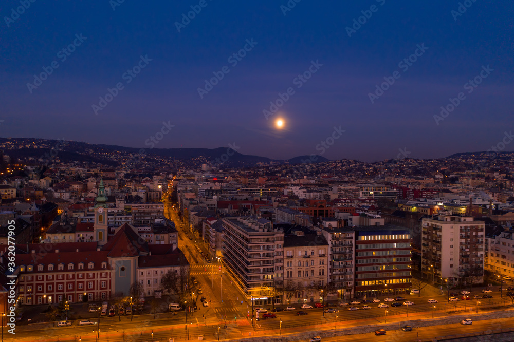 Aerial drone shot of Church of St. Francis in Buda hill at Budapest dawn with moon