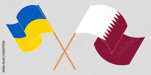Crossed and waving flags of the Ukraine and Qatar