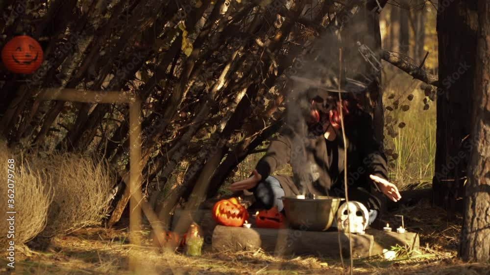 Witch prepares a potion in a cauldron in a forest hut. Theme of the