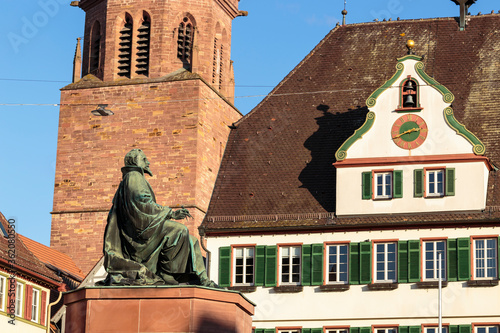 Horizontal view of monument of astronomer and mathematician Johannes Kepler, erected in the town of Weil der Stadt in 1870, and the Church of Saints Peter and Paul in the background photo