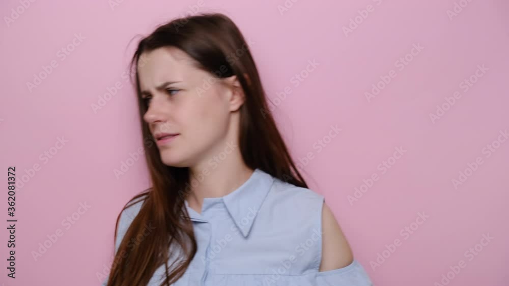 Close up portrait of serious frustrated young caucasian woman stops listening to someone and go away, dressed in blue shirt, isolated on pink studio background. Don't want to hear you! Close up portrait of serious frustrated young caucasian woman stops listening to someone and go away, dressed in blue shirt, isolated on pink studio background. Don't want to hear you!