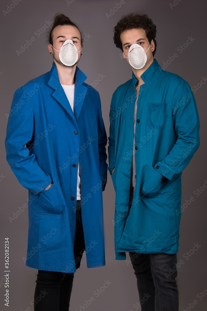 workers wearing mask and blue protective work wear coat, isolated studio shot 