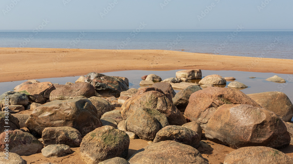 Nice landscape with boulders of different sizes by the sea on a sunny day. Latvia. The rocky coast of Vidzeme Nice landscape with boulders of different sizes by the sea on a sunny day. Latvia. The rocky coast of Vidzeme