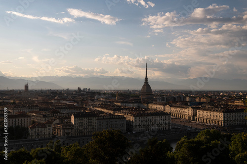 Foto di panorama urbano della città di Torino con vista montagne all'orizzonte e nuvole nel cielo.