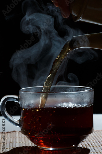 hot tea is poured into a mug