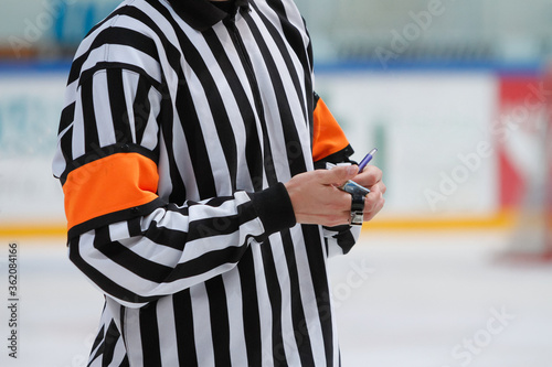 Photography An ice hockey referee making notes on a small notebook during a game break