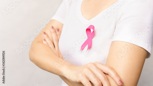 Wallpaper Mural Portrait of woman standing crossed arms over chest, wear white t-shirt with pink ribbon pin as a symbol of support on breast cancer day campaign. Torontodigital.ca
