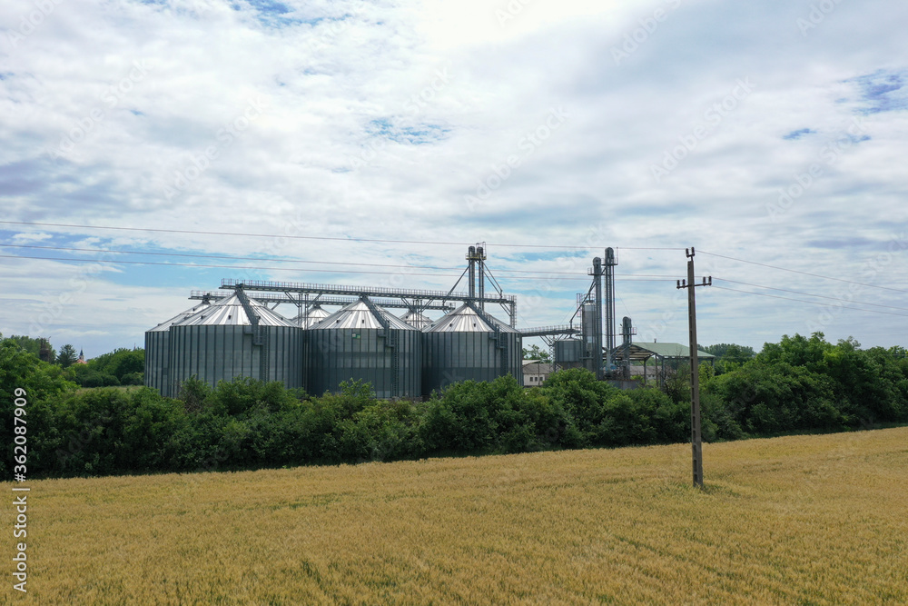 Agricultural silos on a farm, photos from above with a drone. Industrial agricultural granary, processing plant, elevator dryer, storage and drying of cereals, wheat, corn, soybeans, sunflowers. Agricultural silos on a farm, photos from above with a drone. Industrial agricultural granary, processing plant, elevator dryer, storage and drying of cereals, wheat, corn, soybeans, sunflowers.