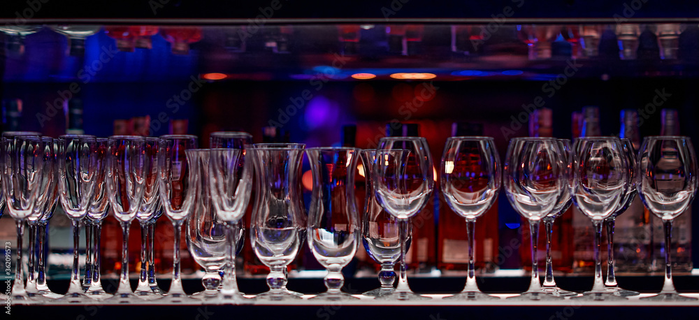 colorful row of empty wine glasses on the shelf in the bar colorful row of empty wine glasses on the shelf in the bar