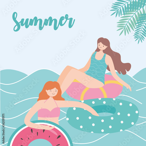 summer time beach vacation women resting on floating rubber rings on sea