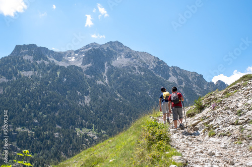 two boys doing trekking reaching the top of the mountain