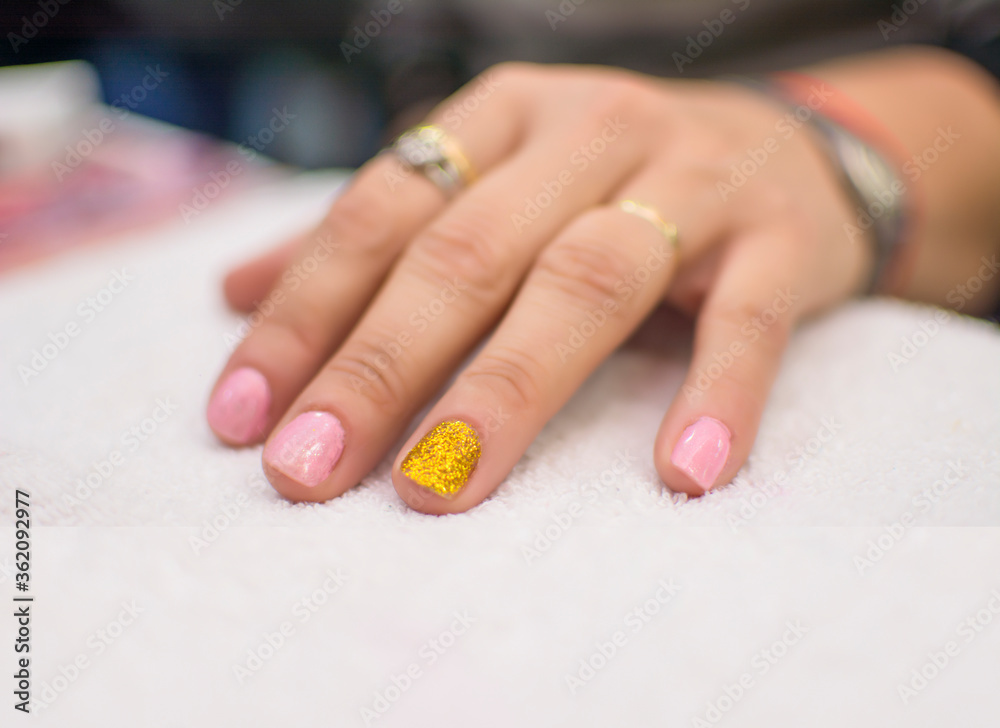 Beautiful semi-permanent manicure nails. Light manicure in light on a white background in a beauty salon Beautiful semi-permanent manicure nails. Light manicure in light on a white background in a beauty salon