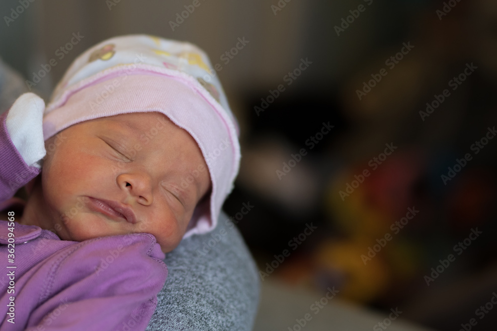 Mom holds her one month old baby girl on the shoulder while she is sleeping. Mom holds her one month old baby girl on the shoulder while she is sleeping.