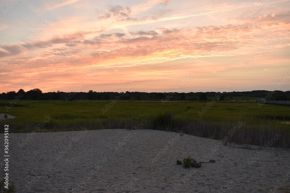 Naklejka premium sunset near sand and grass