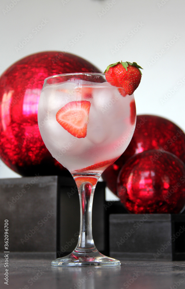 Gin tonic de fresa en mesa vintage y esferas rojas Stock Photo Adobe