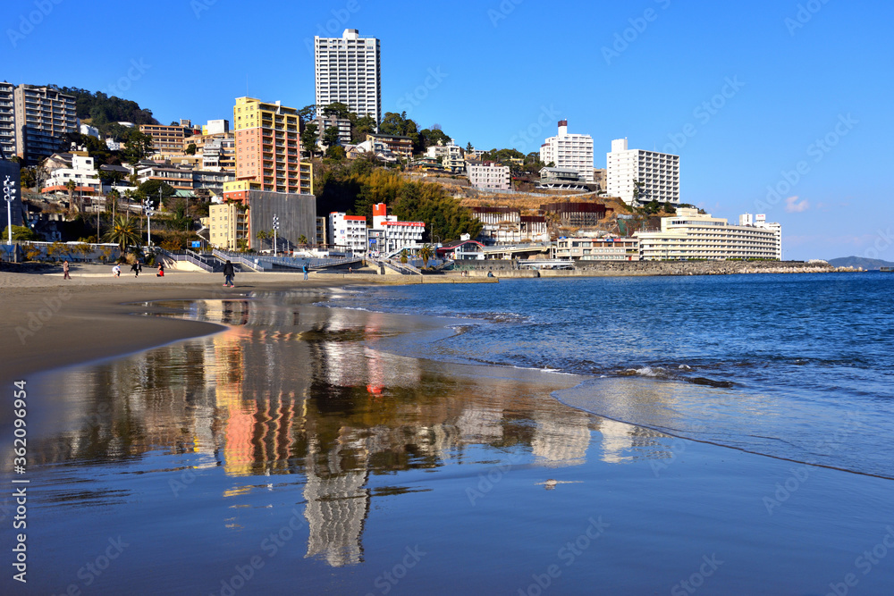 Fototapeta premium 熱海のビーチに映り込む丘陵に建つマンション群