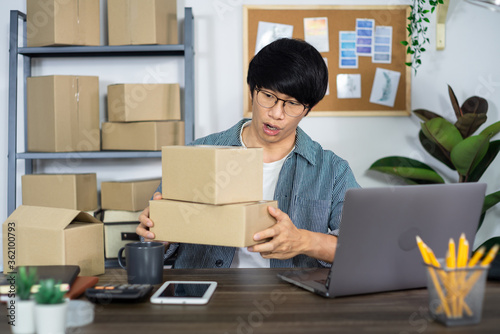 Asian business man startup SME entrepreneur working in a cardboard box prepares delivery box for customer
