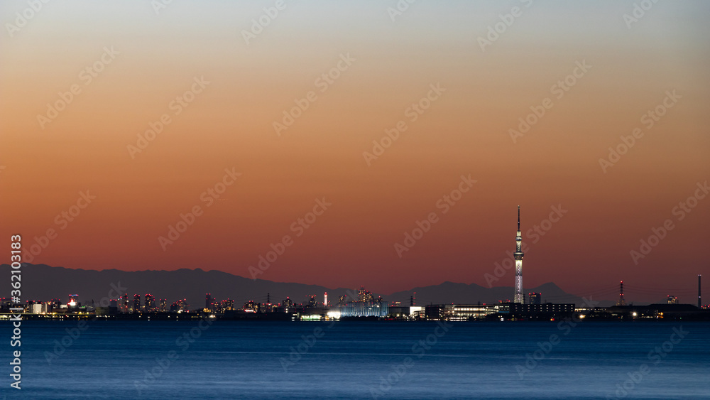 夕焼けを背景に千葉舞浜から東京湾越しに見た東京と山々