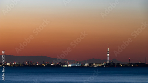 夕焼けを背景に千葉舞浜から東京湾越しに見た東京と山々 © maruboland