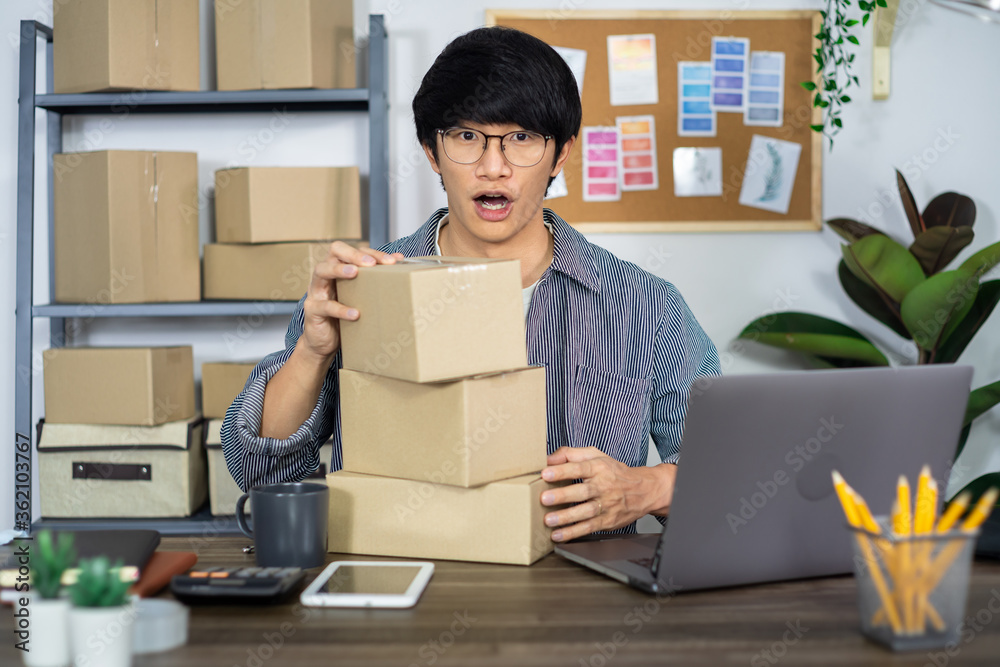 Asian business man startup SME entrepreneur working in a cardboard box prepares delivery box for customer Asian business man startup SME entrepreneur working in a cardboard box prepares delivery box for customer