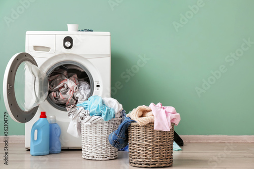 Washing machine with dirty clothes near color wall