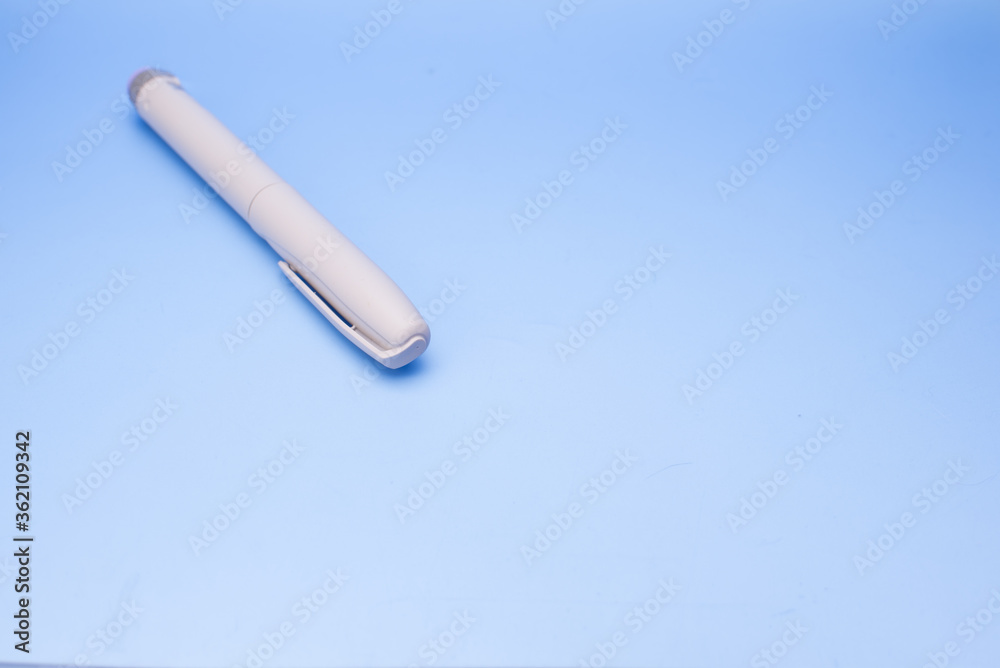 Insulin pen isolated over blue background Insulin pen isolated over blue background