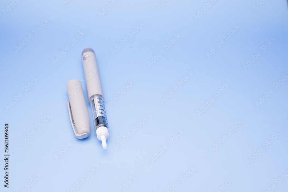 Insulin pen isolated over blue background Insulin pen isolated over blue background