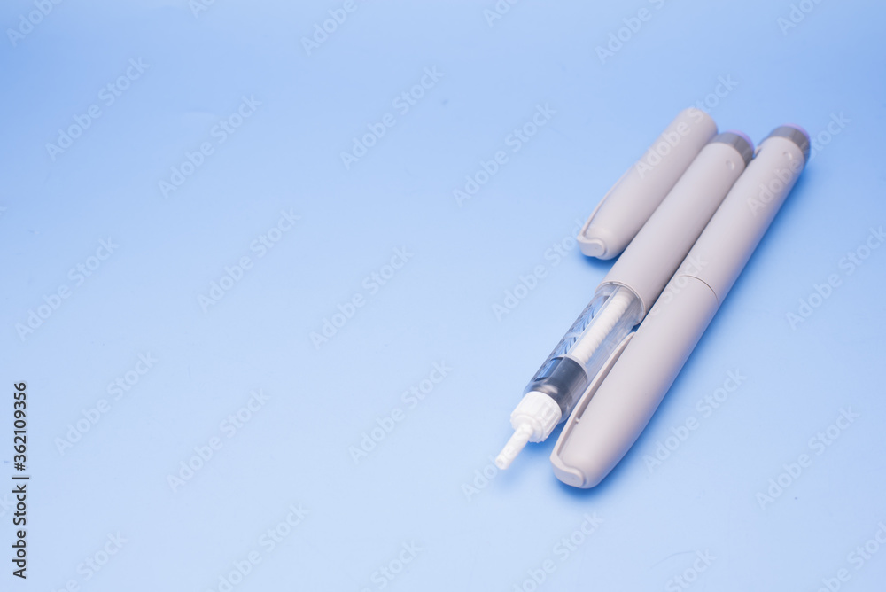 Insulin pen isolated over blue background Insulin pen isolated over blue background