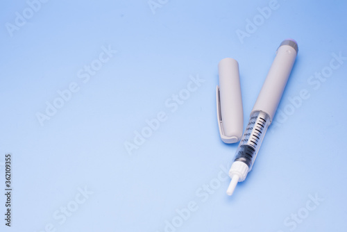 Insulin pen isolated over blue background