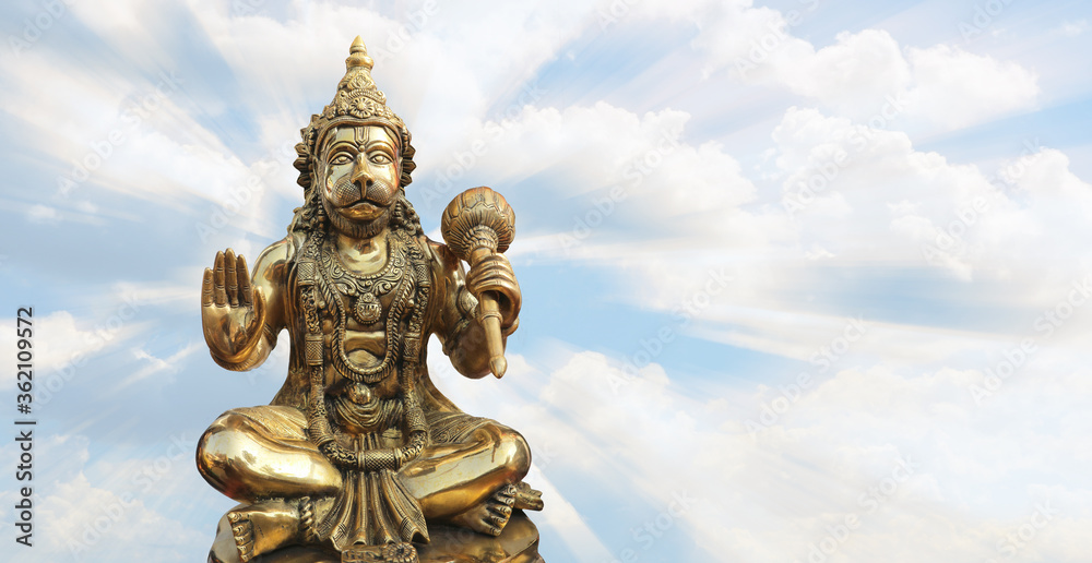Bronze Hanuman on the background of light cloudy sky.