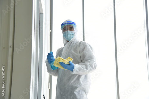 A man in protection germ suit or PPE suit with Equipment Face shield, Mask, and Alcohol gel for cleaning place and fighting Corona virus (covid 19) outbreak quarantine/disinfection