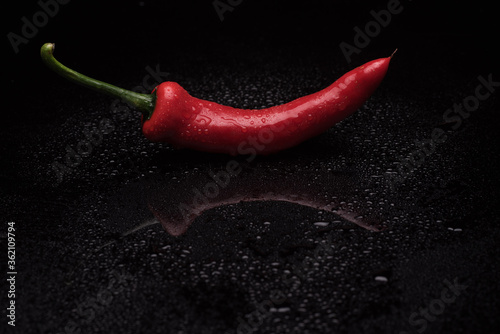 Heap of chili over dark reflective surface