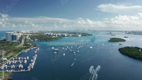 Drone is flying above the Miami Harbor. 4K aerial slow motion of yachts sailing to the popular tourist attraction - beach island in the middle of the bay. Sunny summer day at Caribbean tropical region