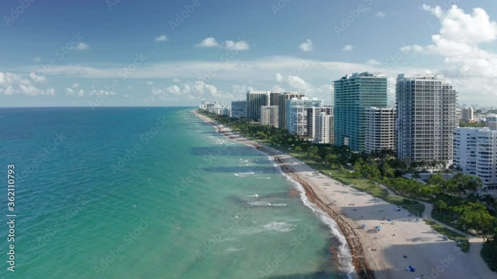 4K aerial view of clean light-green sea waters. Residential front line buildings with beautiful Atlantic ocean view. South Beach nature at sunset, Florida, USA. Ideal background for travel business.