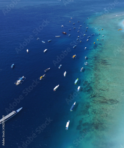 Indonesia November 29, 2020: a tropical island with a white sandy beach and blue transparent water and coral reefs. Aerial shooting, speedboats, longtail boats, Gili Trawangan island Indonesia 
