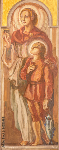 BARCELONA, SPAIN - MARCH 3, 2020: The fresco of archangel Raphael with the Tobiac in the church Parroquia Santa Teresa de l'Infant Jesus by Francisco Labarta (20. cent.).