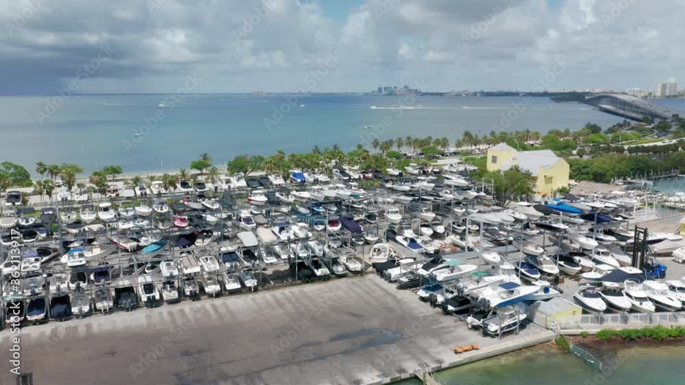 Top view on the yacht parking at the marine club. Beautiful slow motion drone video for water sport business. Sailing club with Miami bay on background, Florida. 4K aerial water transportation Top view on the yacht parking at the marine club. Beautiful slow motion drone video for water sport business. Sailing club with Miami bay on background, Florida. 4K aerial water transportation