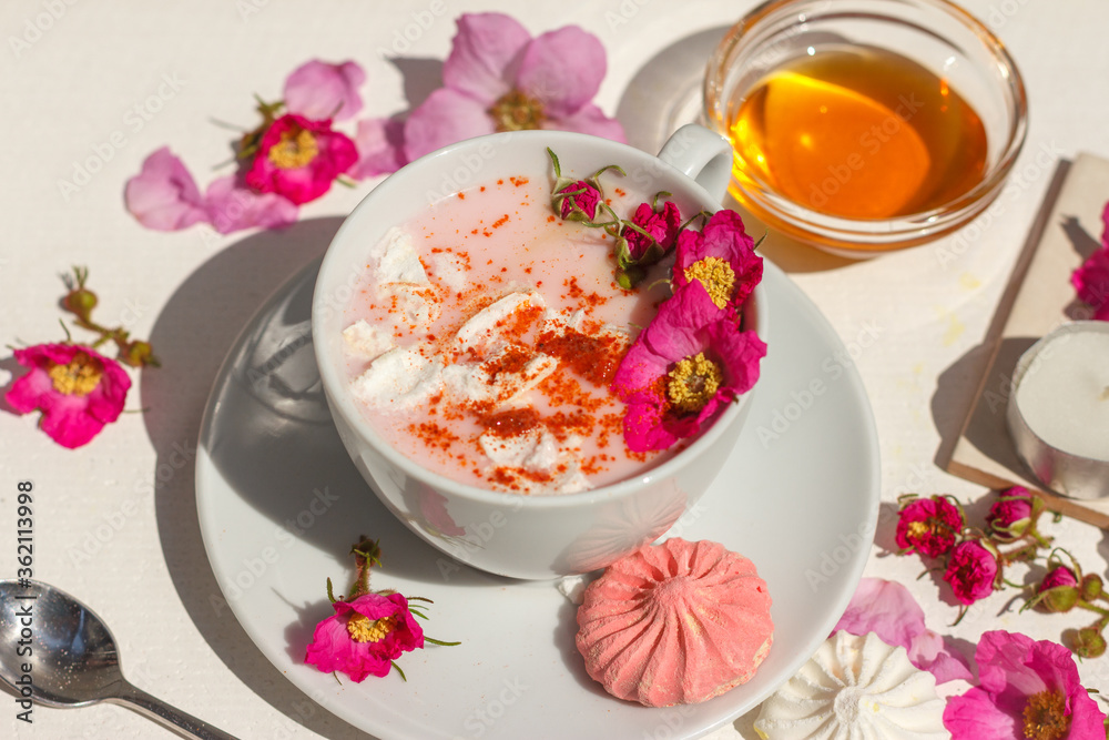 Pink moon milk with spices, marshmallows and wild rose flowers. Close up