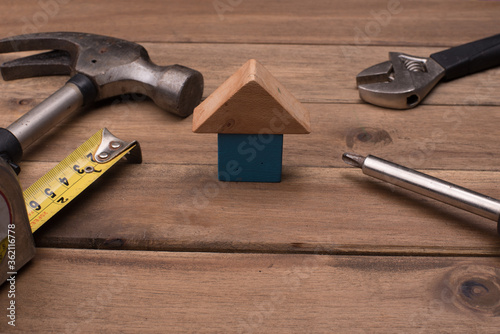 Set of tools with a house symbol,over wooden background