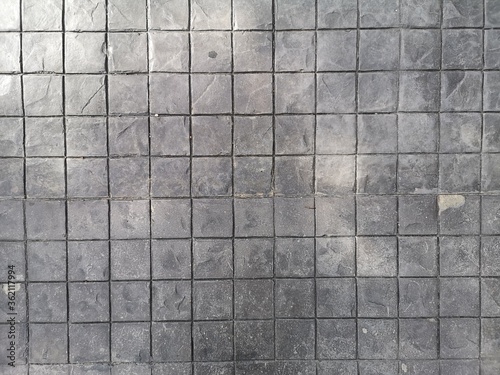 Stamp concrete black color hardener printing patterns on the cement or mortar surface block shape Square pattern material rough texture background