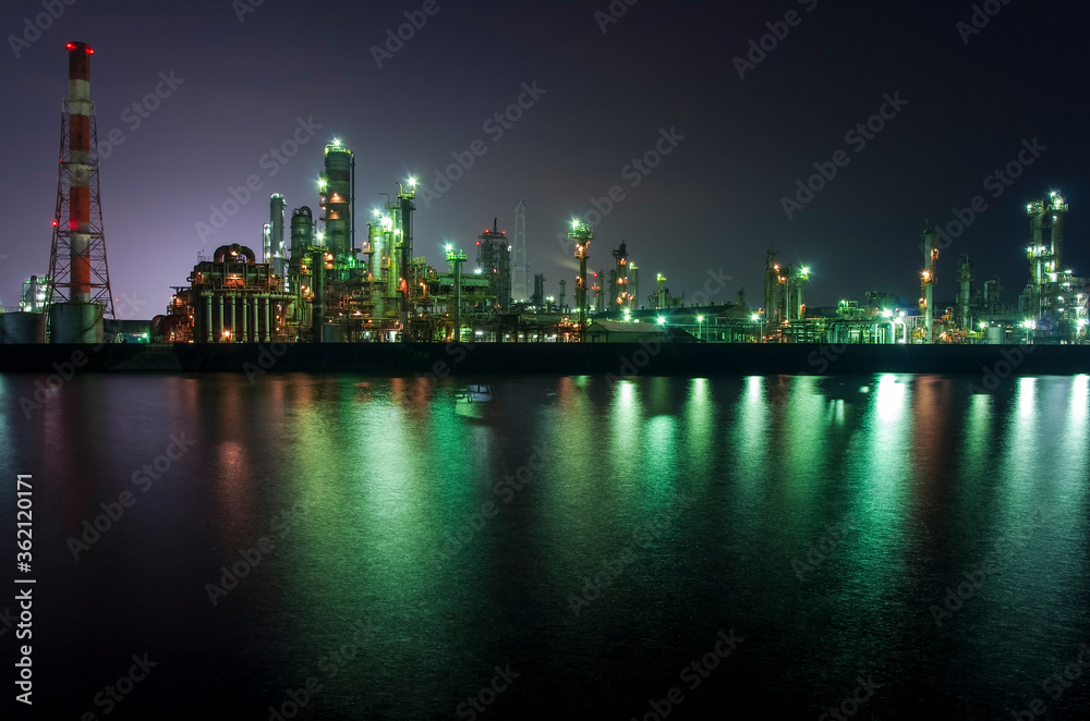 Fototapeta premium プラントの煙突が並ぶ夜の工業地域
